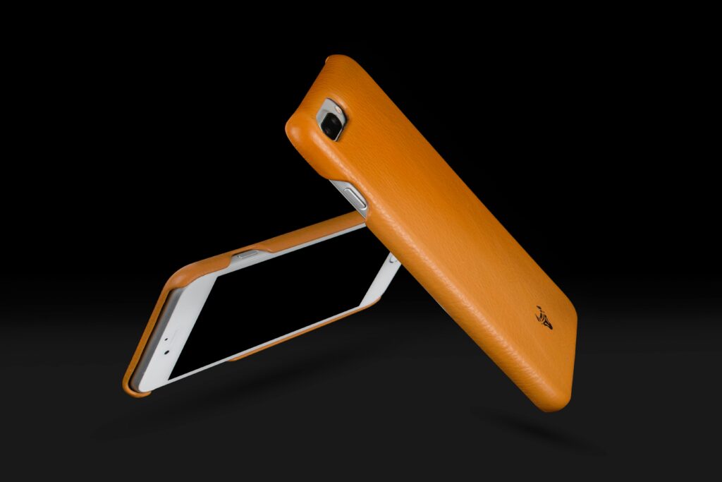 Dynamic image of sleek orange phone cases in a minimalist style, emphasizing modern technology and design.